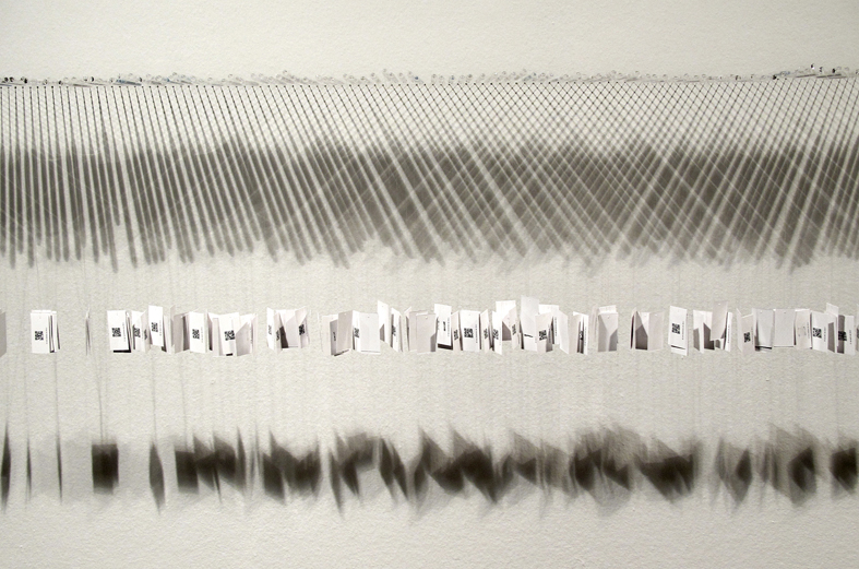 "One year in minutes of silence", 2013. Glass, digital printing on paper and nylon. 50 x 80 x 16 cm.