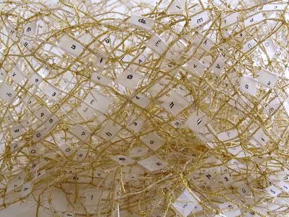 "Cinta de Moebius", 2016. Hilo dorado tejido, plástico adhesivo y papel impreso. 50 x 90 x 0,5 cm.