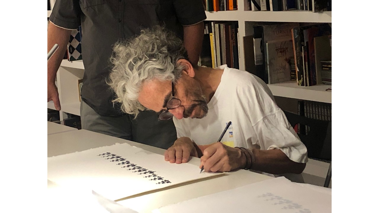 Antonio Caro signing the silkscreen.