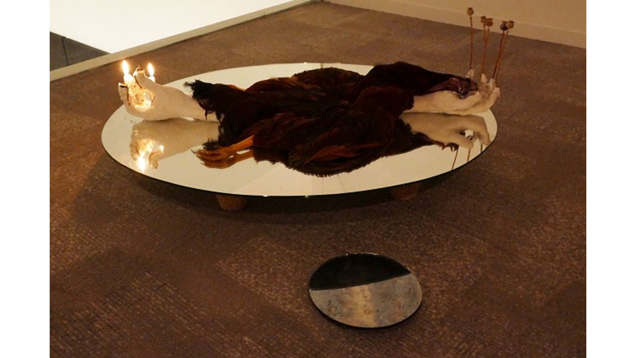 "Nexo", 2020. Espejos, gallo disecado, manos del artista fundidas en escayola, velas y hojas de opio.